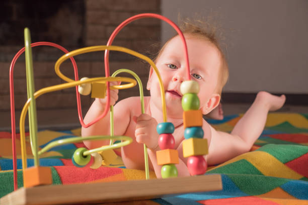 istock Fine motor challenge. Baby plays with toy. Montessori background. Supporting the development of fine motor skills. Fine motor skills developing. Gifts for toddlers, babies. Pediatric background 1201862098