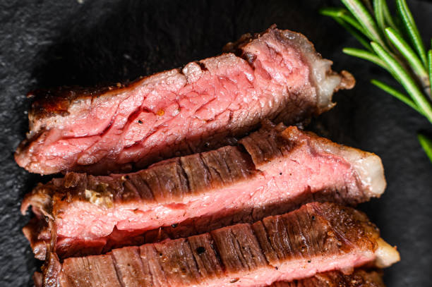 istock Grill Restaurant Beef Menu - Flank Steak on a black stone Board. Black background. Top view 1201863468