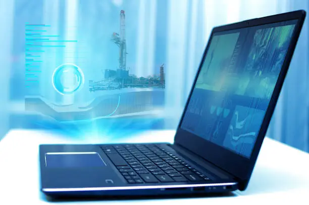 a hologram on a laptop, drilling a well to monitor and analyze geology in oil and gas production. Modern technology and artificial intelligence