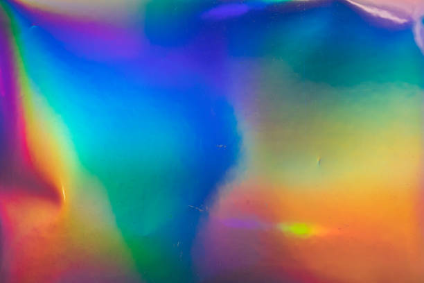 high res macro photo of abstract pastel iridescent holographic foil background with light leaks. stock photo