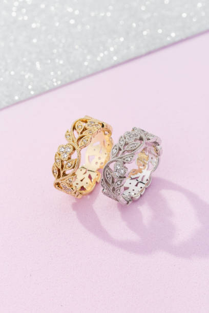 istock Two female wedding rings with floral design on pink background 1201875076