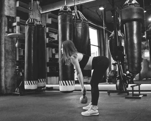 istock Functional training. Woman doing deadlift exercise with kettlebell indoors at gym 1201876337
