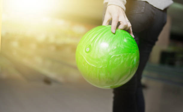 mão de mulher segura bola de boliche verde pronta para lançar - bowling holding bowling ball hobbies - fotografias e filmes do acervo