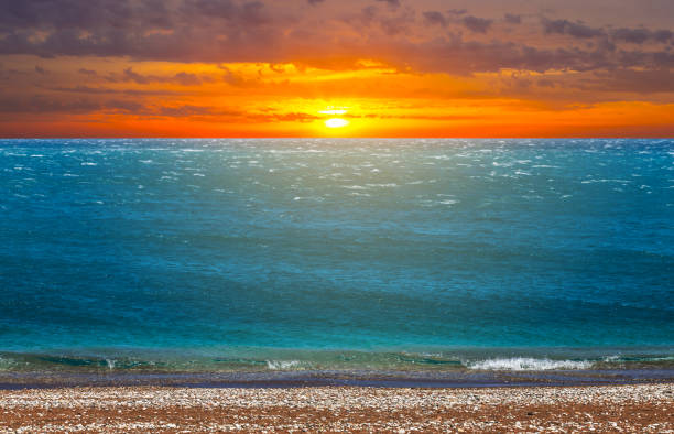 istock red dramatic sunset over the sandy sea beach 1201880085