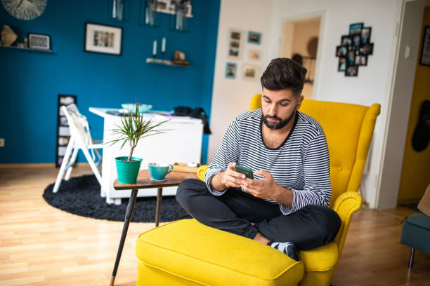 istock Man using smart phone at home in the morning 1201881822
