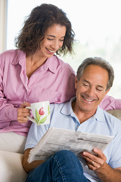 istock Couple relaxing with newspaper smiling 120188567
