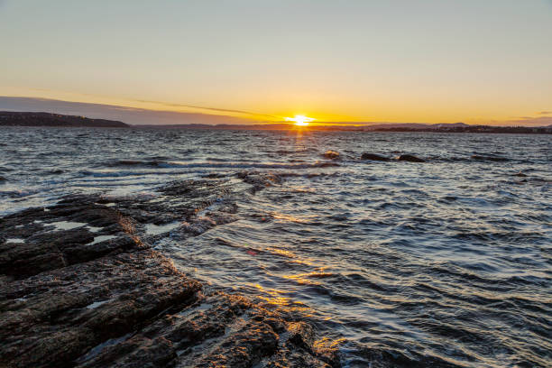 istock Sunlight over a beautiful landscape with waves to a shore at dusk 1201887173