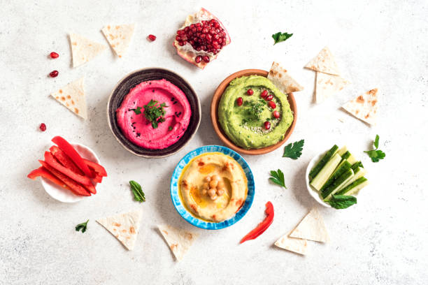 Colorful hummus bowls Colorful hummus bowls, healthy vegan dips. Traditional Middle eastern hummus, green hummus, beetroot hummus, spread. Assorted meze and dips with pita bread. Meze and snacks set, copy space. jordan middle east photos stock pictures, royalty-free photos & images
