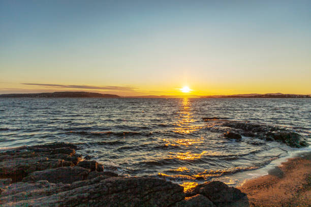 istock Sunlight over a beautiful landscape with waves to a shore at dusk 1201888871