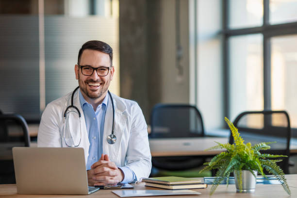 istock Portrait Of Male Doctor In Office Working At Computer. 1201889013