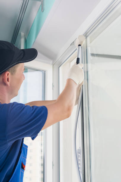 istock window installation worker inserts glass into the frame and fastens the window with a rubber mallet, side view 1201889173