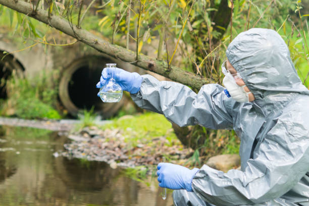 istock environmental biologist in a protective suit and mask examines water from the river for viruses 1201889233