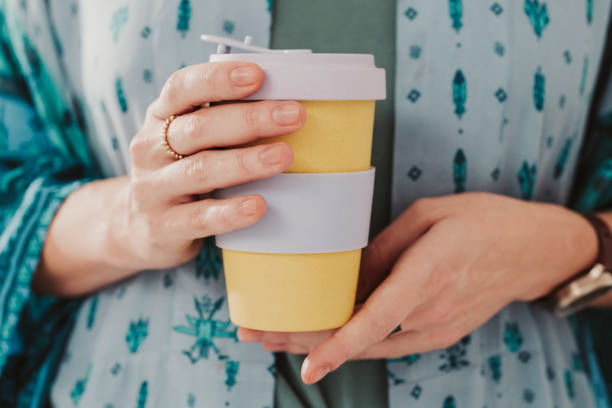 Woman holding to go take out coffee cup