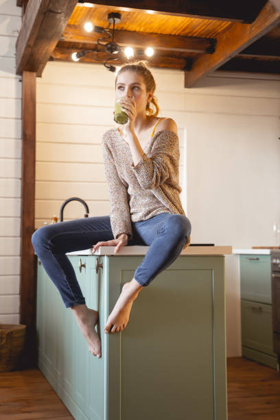 istock Cheerful young blonde girl drinking tasty smoothie 1201891739