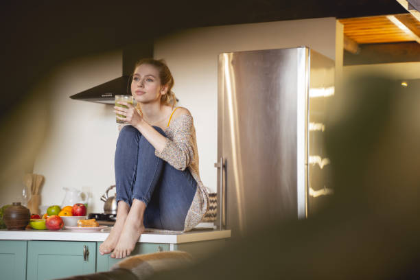 istock Relaxed young woman sitting in the kitchen 1201891744