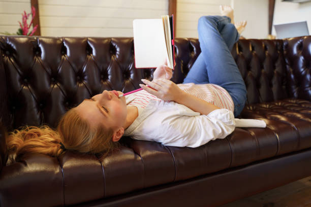 istock Charming young blonde lying on her cozy sofa 1201891869