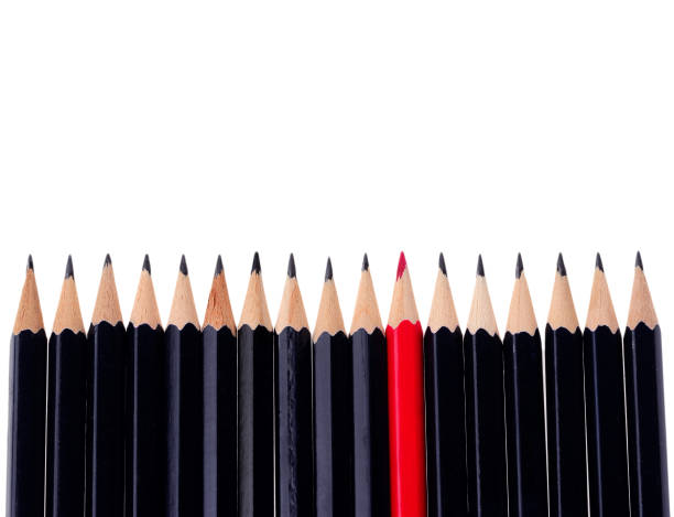 istock Red pencil standing out from crowd of plenty identical black fellows on white background. business success concept 1201895301