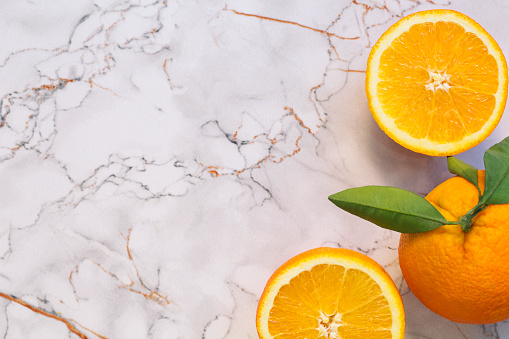 Fresh ripe oranges on white stone background. Top view with copy space