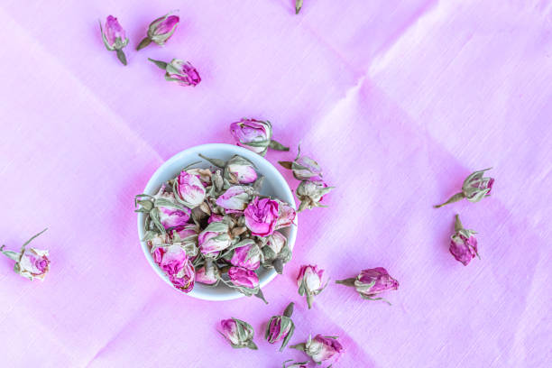 istock Dried roses in a white cup at pink pastel background. 1201896498