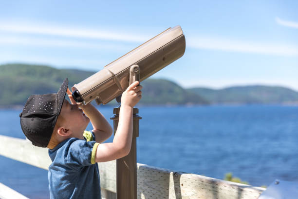 istock Little Redhead Boy Whale Watching With Binoculars in Summer 1201898271