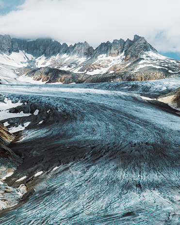 Dramatic view of Rhone melting glacier, blue glacial lake and the Swiss Alps at Furka Pass, Switzerland