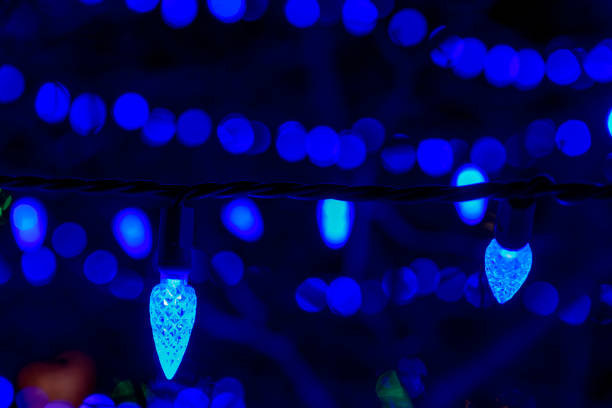 istock Close up of Christmas light that are blue and, on a tree, 1201911490