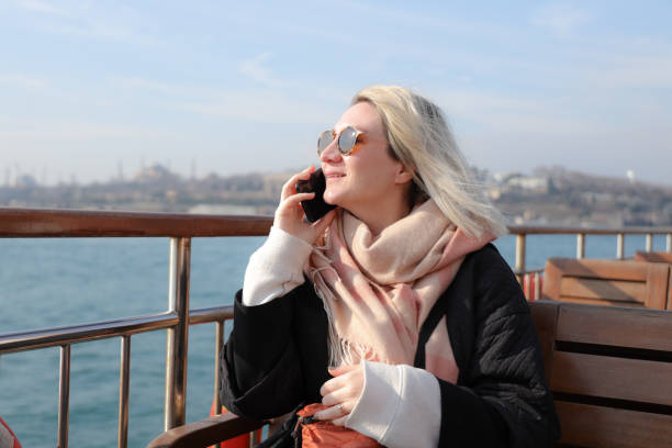 istock Young woman traveling by ship and using smart phone 1201912590