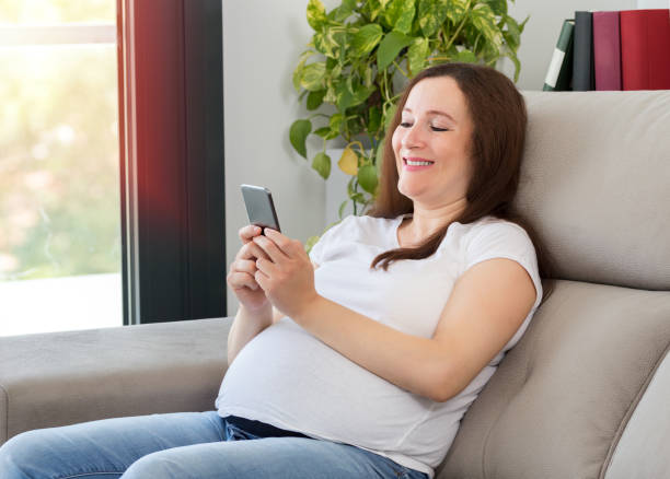 istock pregnant woman texting on a mobile phone 1201914274