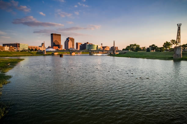 Dayton Over Water A low aerial view via drone over the Great Miami River in downtown Dayton, OH looking at the skyscrapers and economic center of downtown at sunset in the summer. dayton ohio skyline stock pictures, royalty-free photos & images