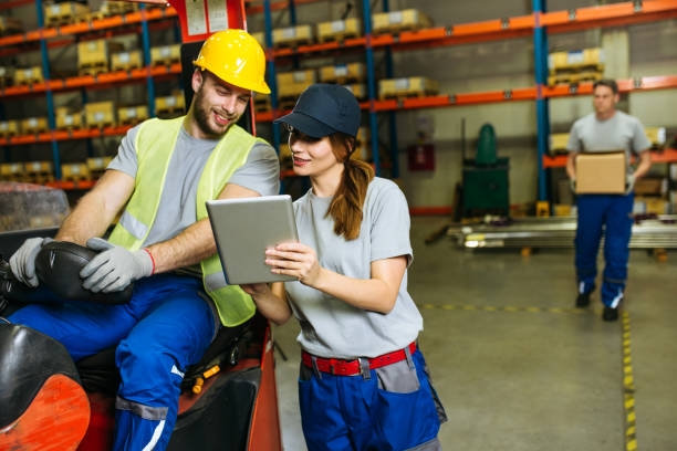 istock Female supervisor evaluate work in storage room and writing at notepad 1201919700
