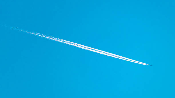 istock Airplane Vapor Trail Streaking Across a Blue Sky 1201919939