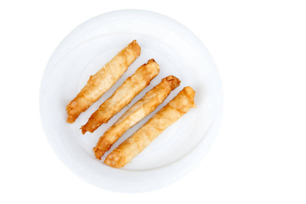 хрустящие, свежеиспеченные сырные палочки во фритюре на белой тарелке. изолированное изображение. вид сверху. восточная кухня - twisted cheese biscuit pastry стоковые фото и изображения
