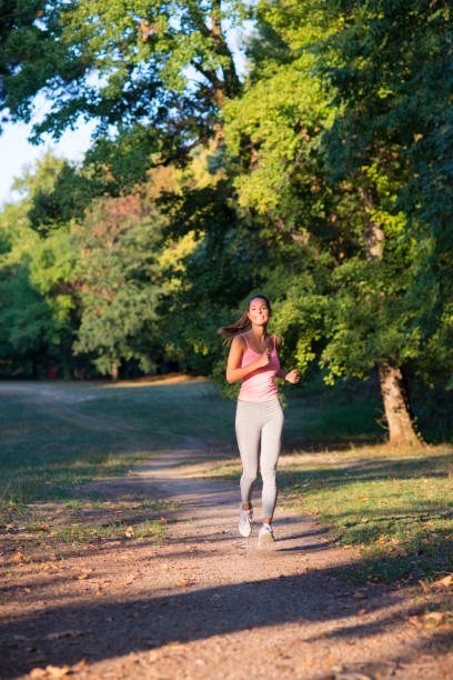 istock Young woman running in the park 1201920301
