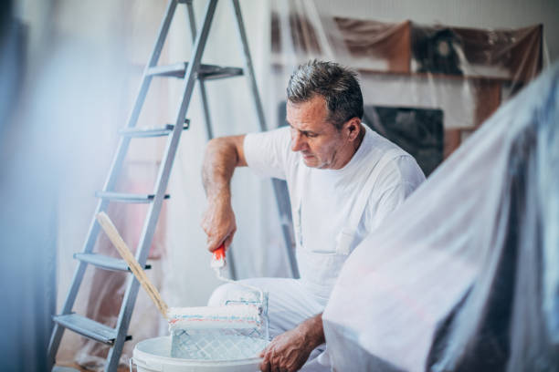 The painter prepares paint for the decoration of the apartment The painter prepares paint for the decoration of the apartment house painter ladder paint men stock pictures, royalty-free photos & images