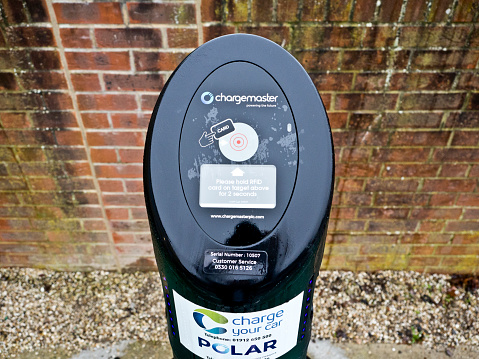 Polar chargemaster charging point station for electric hybrid cars or vehicles, in the United Kingdom. Power supply connected to electric vehicle for charge to the battery. Charging technology industry transport which is current of the Automobile. EV fuel Plug-in hybrid car or vehicle.