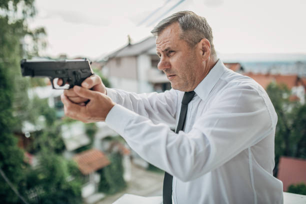 istock Senior man with a gun in his hand 1201927738