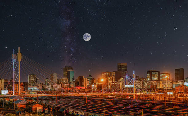 ヨハネスブルグ市のスカイラインとネルソンマンデラ橋の夜、空に月と銀河 - nelson mandela bridge cityscape bridge south africa ストックフォトと画像