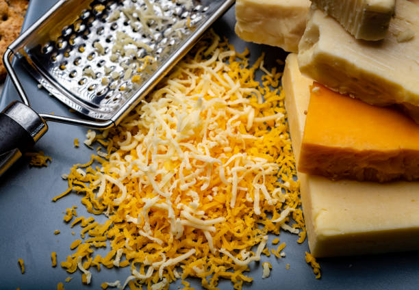 istock Cheese collection, matured and orange original British cheddar cheese in blocks and grated served on grey plate 1201931295