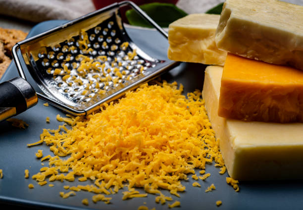 istock Cheese collection, matured and orange original British cheddar cheese in blocks and grated served on grey plate 1201931306