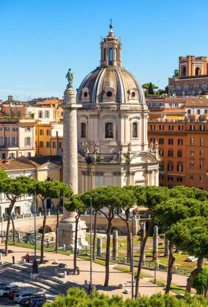 Photo of Rome in summer, Italy. Nice scenic view of Ancient Roman Trajan's Column in the Rome city center. Beautiful cityscape of Rome with old buildings.