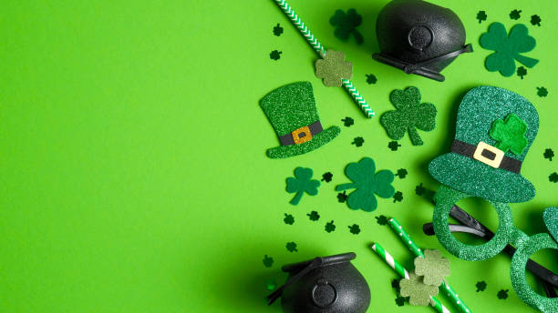 istock Happy Saint Patricks Day flat lay composition with shamrock leaf clovers, party glasses, Irish elf hat, pots of gold, drinking straws. St. Patrickâs Day greeting card template, banner design 1201934237