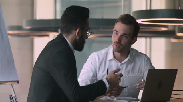 Confident salesman financial advisor explaining deal details to arabic client.