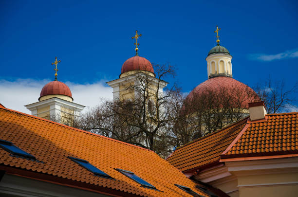 Church domes with crosses and red tiled roofs and blue sky on background, Vilnius, Lithuania