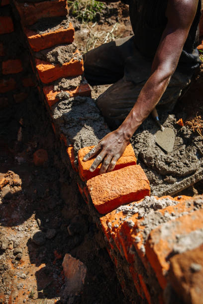 istock Man building a brick wall in Uganda 1201938946