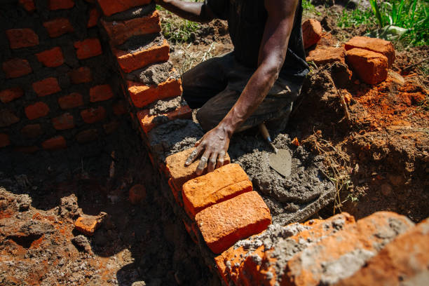 istock Man building a brick wall in Uganda 1201939745
