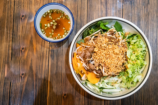 Healthy vietnamese stir fried beef with vermicelli and various vegetable with dip sauce
