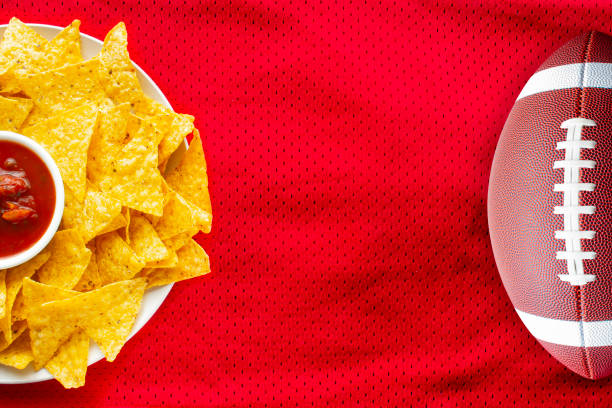 american football jersey textured with a football and nachos with a salsa dip on a horizontal view - american football football food snack imagens e fotografias de stock