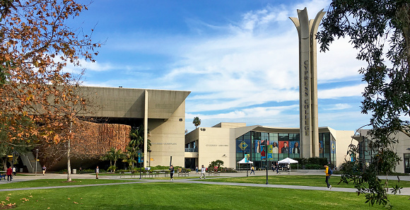 Cypress, CA / USA - Jan 29, 2019: The entrance to Cypress College, located in Orange County, California, features a wide expanse of lawn and well-known examples of Brutalism, also known as Brutalist, architecture.

Brutalism is known for its stark, geometric designs and use of raw concrete. Construction on the campus began just 90 days before the college opened for instruction in September 1966. Today, the campus features 17 major buildings. Brutalism was a popular style in the 1950s and early 1960s for North American college campuses due to the architecture's low cost and ease of construction.