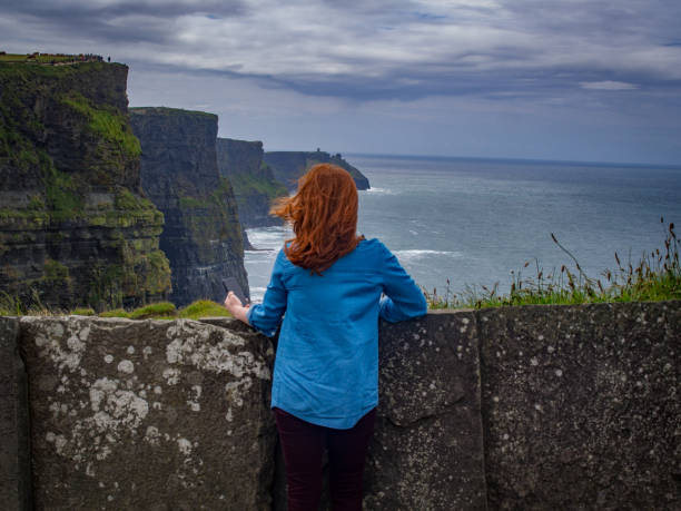 istock Red Haired Women Observing the Majestic Cliffs 1201983141
