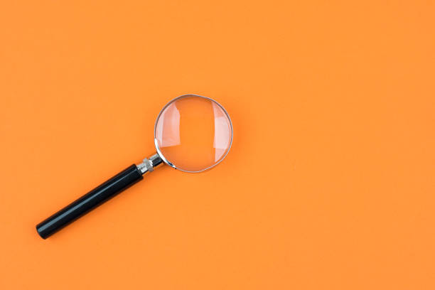 istock Magnifying glass isolated orange background 1201983227